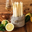 Fresh white asparagus with ingredients for a menu on rustic wood. Kitchen scene for a seasonal and healthy gastronomy concept. Close-up.